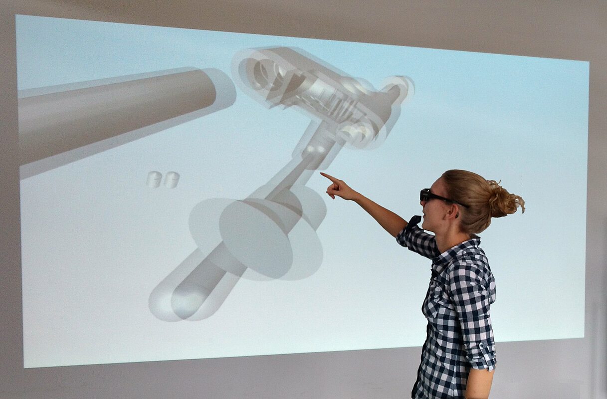 Eine Studentin zeigt auf einem Whiteboard auf eine 3D-Animation eines technischen Tools