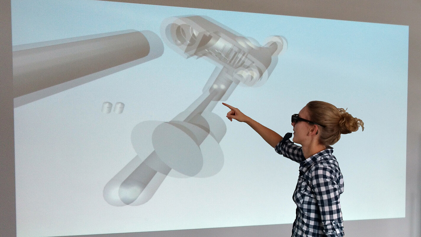 Eine Studentin zeigt auf einem Whiteboard auf eine 3D-Animation eines technischen Tools