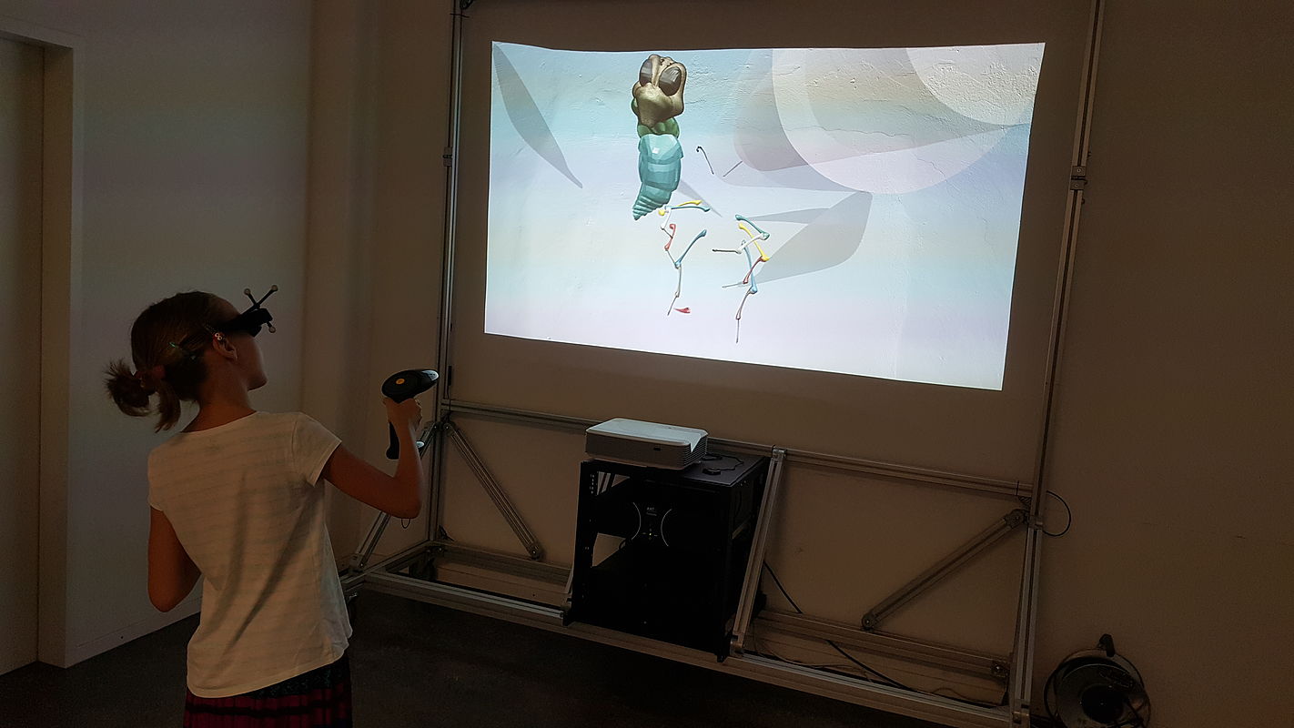 Eine Studentin zeigt auf einem Whiteboard auf eine 3D-Animation eines technischen Tools